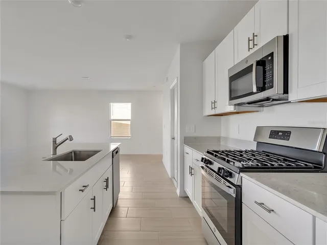 a kitchen with stainless steel appliances granite countertop a sink and a microwave