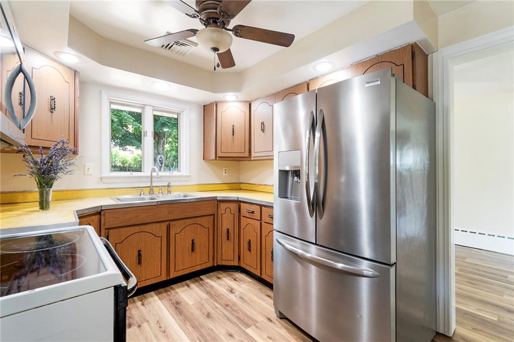 8855 Peebles Road Allison Park, PA 15101 - Photo 8 of 26 a kitchen with stainless steel appliances granite countertop a refrigerator a sink and white cabinets with wooden floor