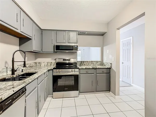 a kitchen with stainless steel appliances granite countertop a stove sink and cabinets