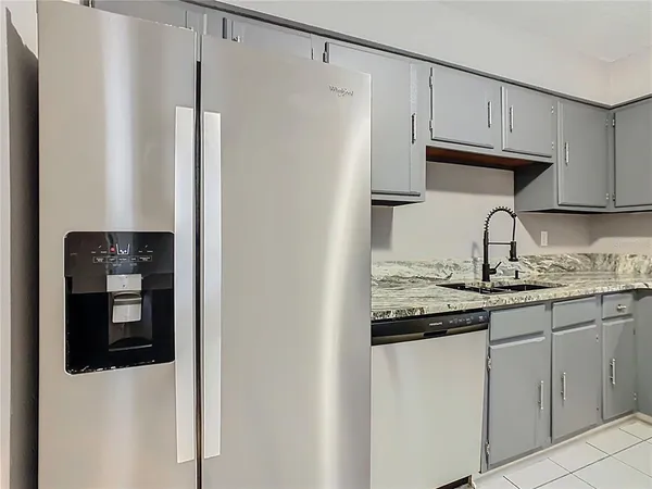 a kitchen with stainless steel appliances granite countertop a refrigerator and a sink