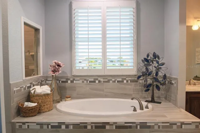 a bathroom with a tub sink and mirror