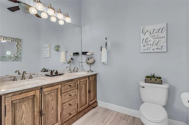 a bathroom with a granite countertop toilet sink and mirror