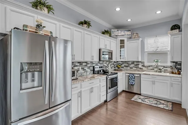 a kitchen with granite countertop a refrigerator stove and sink