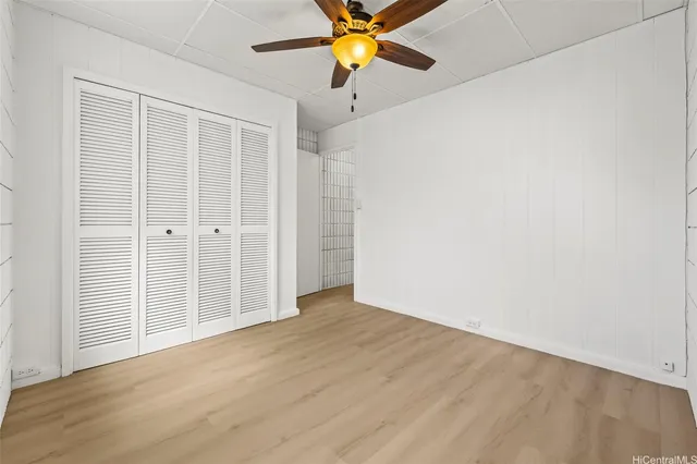 an empty room with a window and a fan