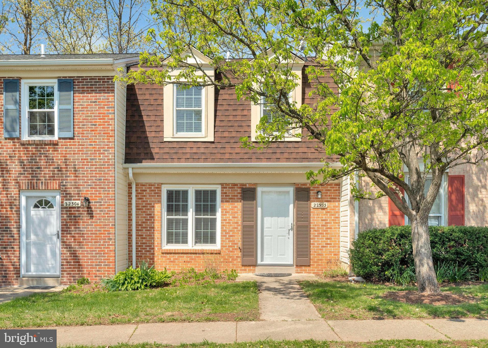 front view of a brick house with a yard