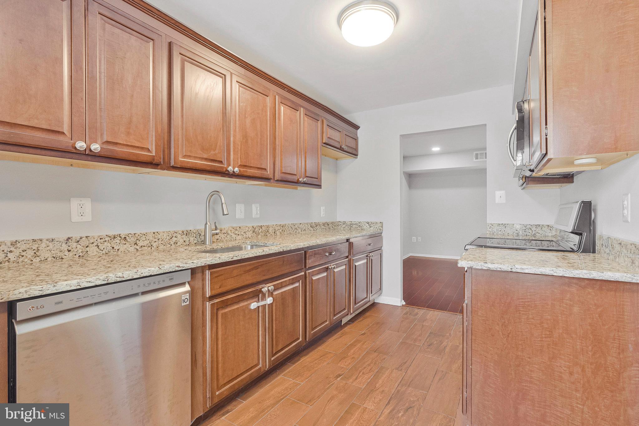 22303 Mayfield Square Sterling, VA 20164 - Photo 8 of 24 a kitchen with stainless steel appliances granite countertop a sink stove and cabinets