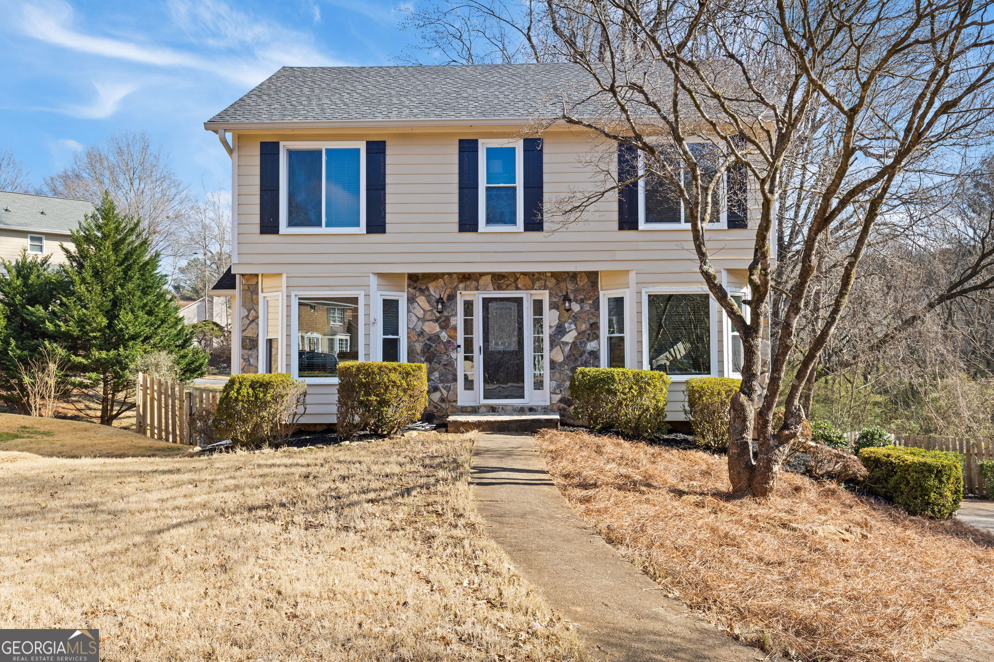a front view of a house with a yard covered in snow