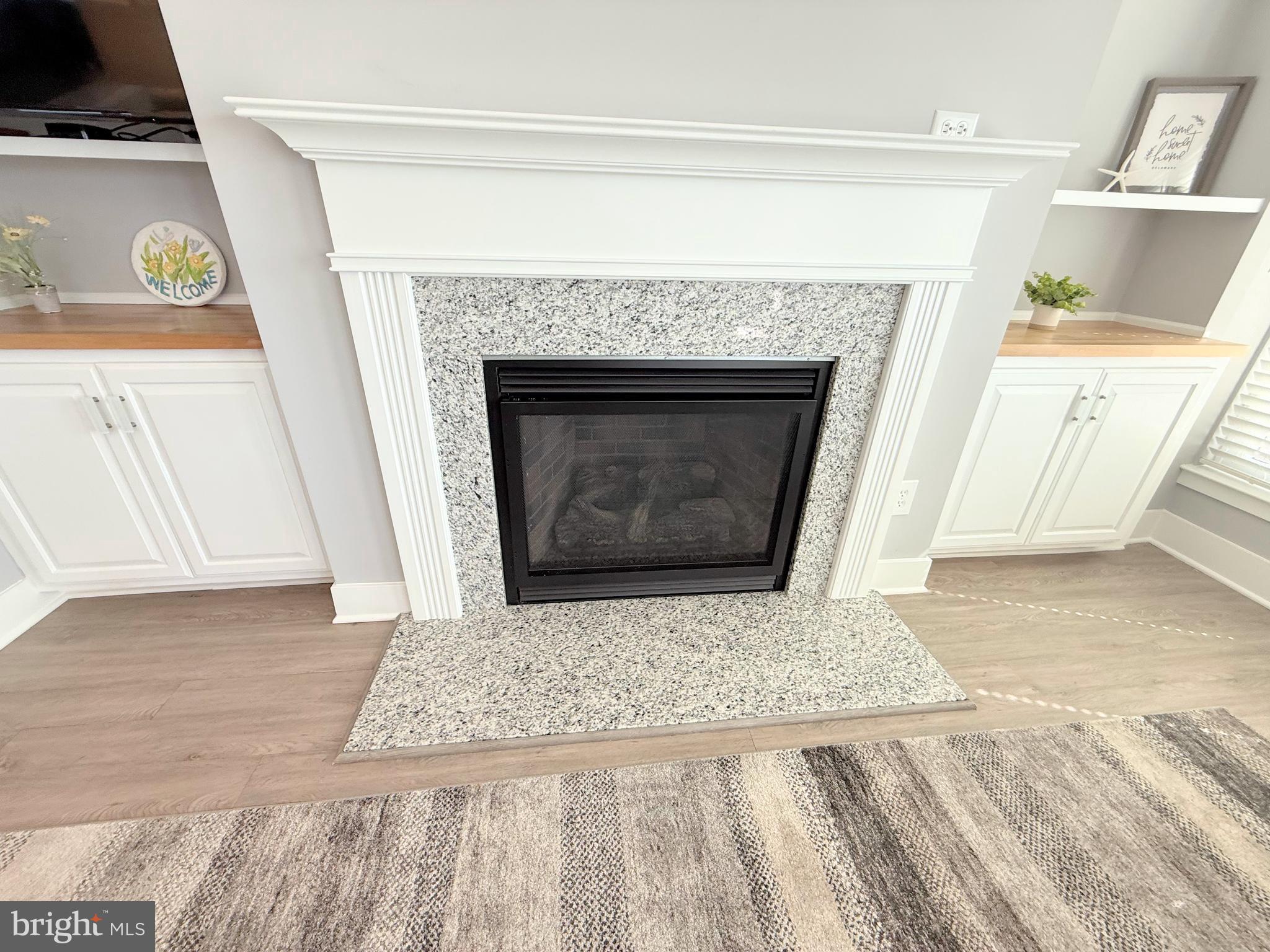 37219 Sandpiper Road, Unit 47 Long Neck, DE 19966 - Photo 24 of 62 a living room with a fireplace and a rug