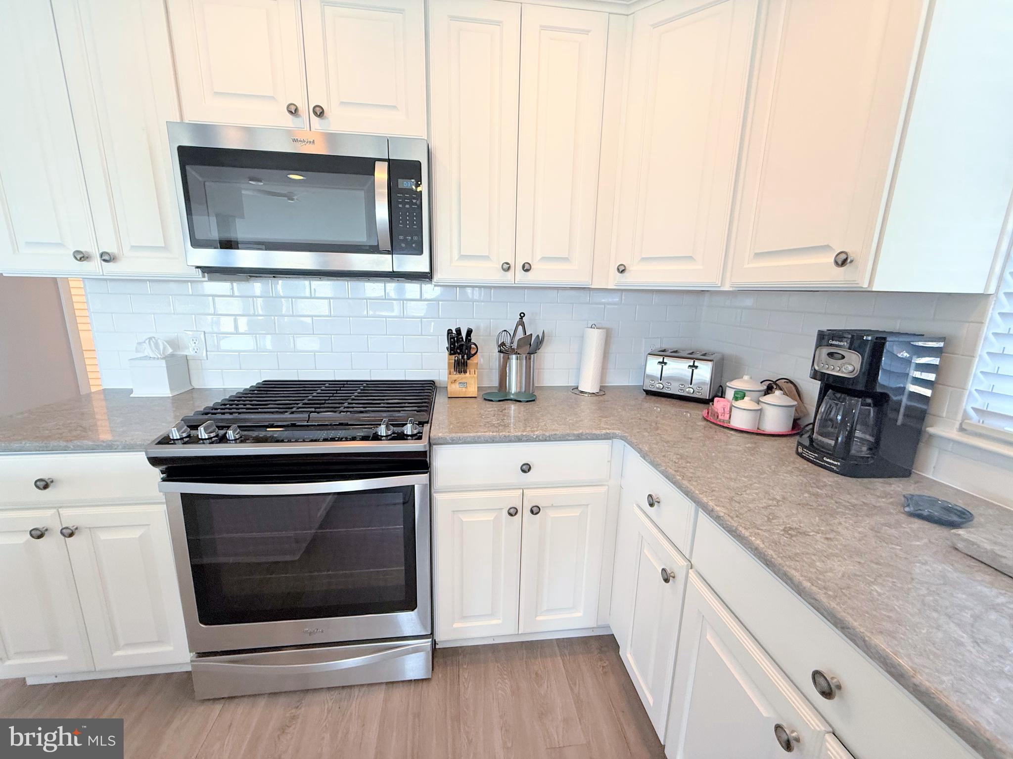 37219 Sandpiper Road, Unit 47 Long Neck, DE 19966 - Photo 28 of 62 a kitchen with stainless steel appliances granite countertop a stove a microwave and cabinets