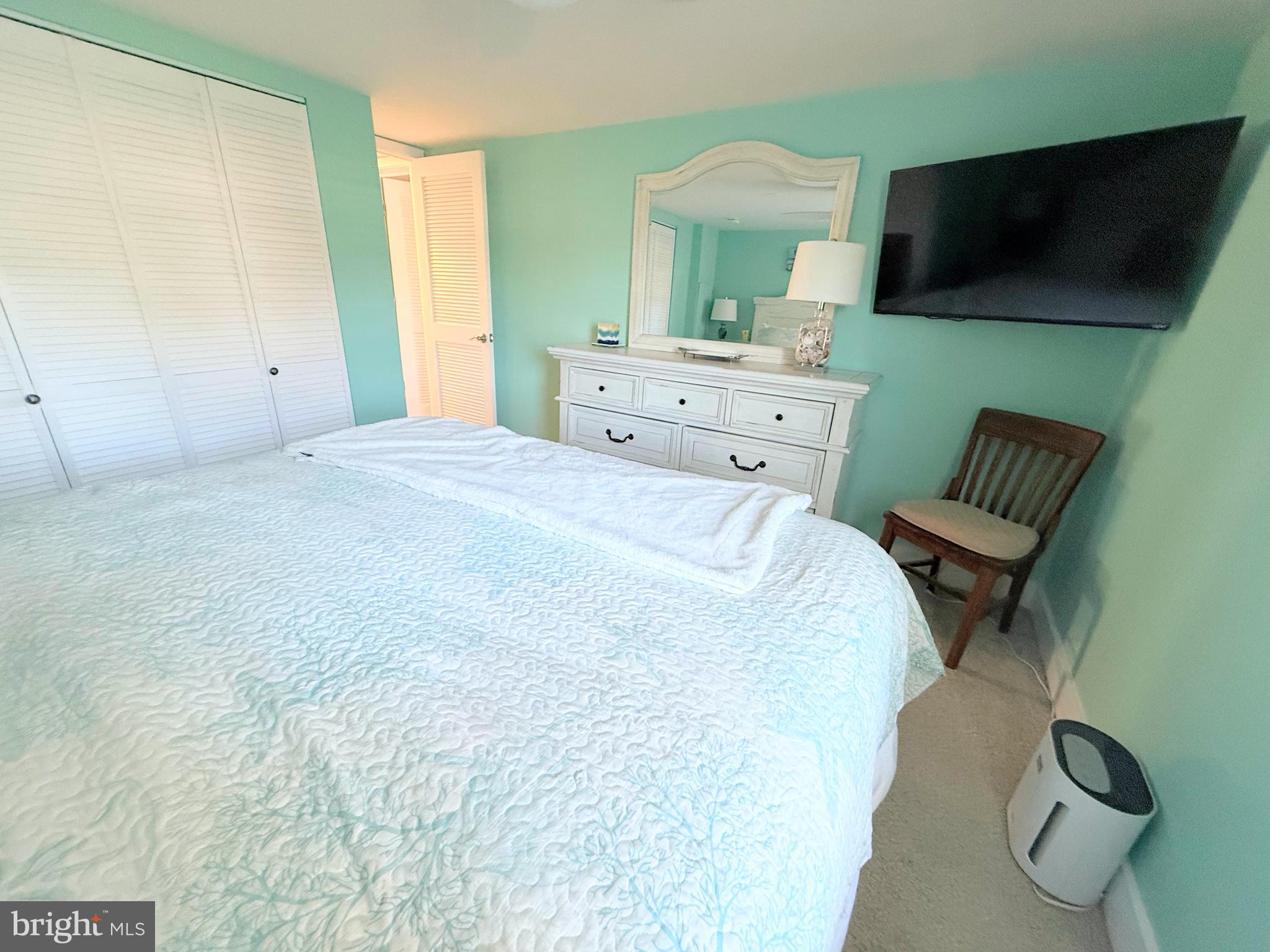 37219 Sandpiper Road, Unit 47 Long Neck, DE 19966 - Photo 36 of 62 a bedroom with a bed and flat screen tv
