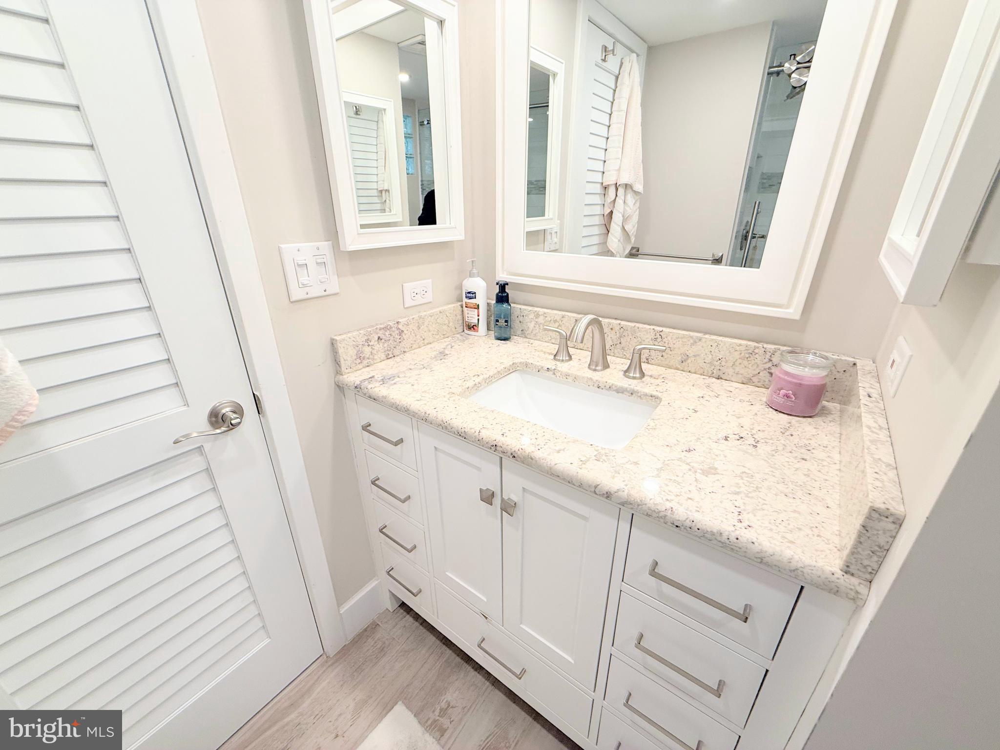 37219 Sandpiper Road, Unit 47 Long Neck, DE 19966 - Photo 41 of 62 a bathroom with a sink and a mirror