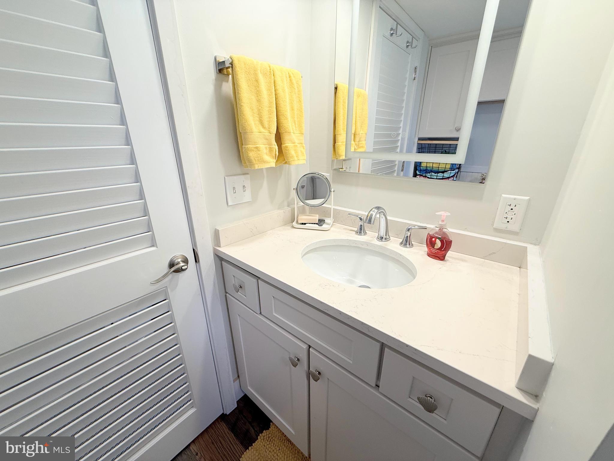 37219 Sandpiper Road, Unit 47 Long Neck, DE 19966 - Photo 46 of 62 a bathroom with a sink and a mirror