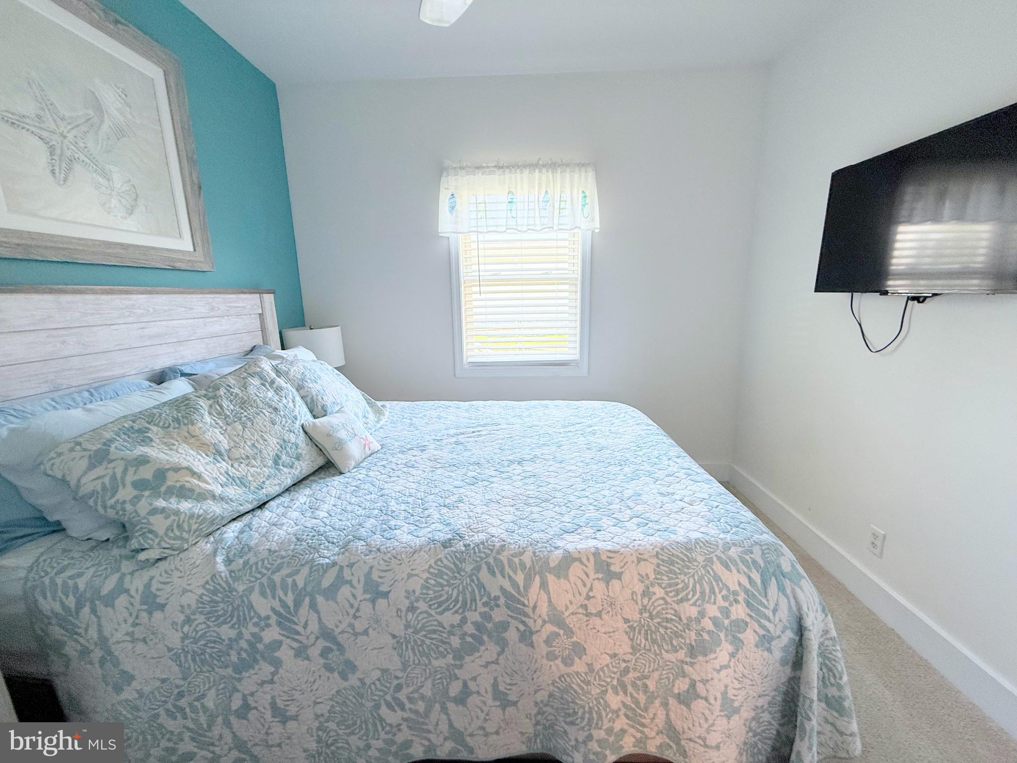 37219 Sandpiper Road, Unit 47 Long Neck, DE 19966 - Photo 50 of 62 a bedroom with a bed and a flat screen tv
