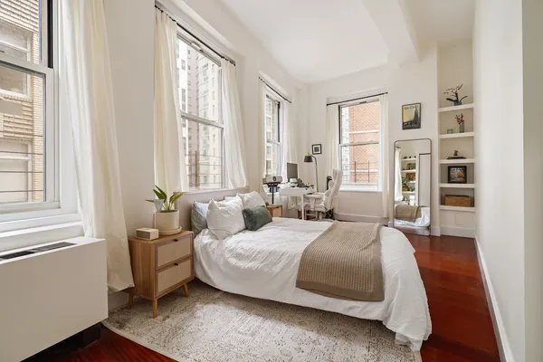 a bedroom with a bed wooden floor and window