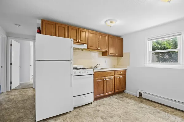 a kitchen with a refrigerator a stove a sink and a window