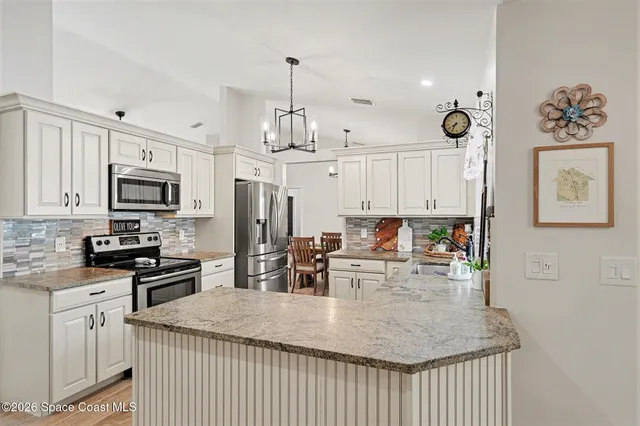 a kitchen with white cabinets sink and stainless steel appliances