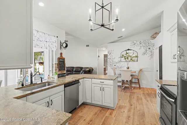 a kitchen with stainless steel appliances a table and chairs in it