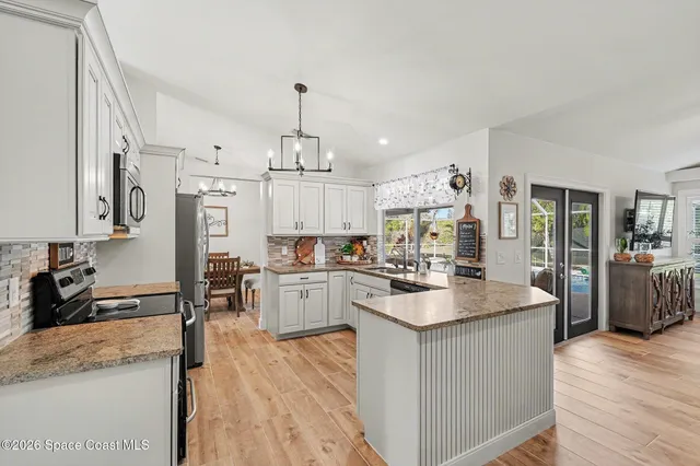 a kitchen with stainless steel appliances kitchen island granite countertop a sink stove and wooden floor