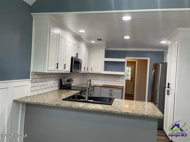 a kitchen with stainless steel appliances granite countertop a sink refrigerator and cabinets