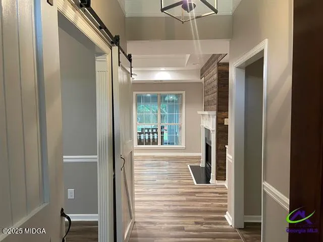 a view of a hallway with wooden floor and a cabinet