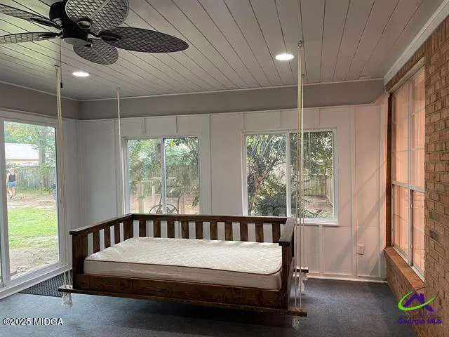 a bedroom with a bed window and a chandelier