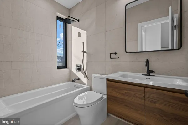 a bathroom with a toilet a sink a tub and mirror