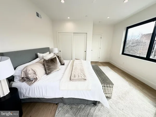 a bedroom with a bed and painting on the wall