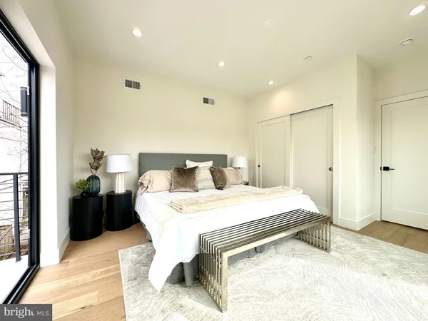 a bedroom with a bed and a large mirror