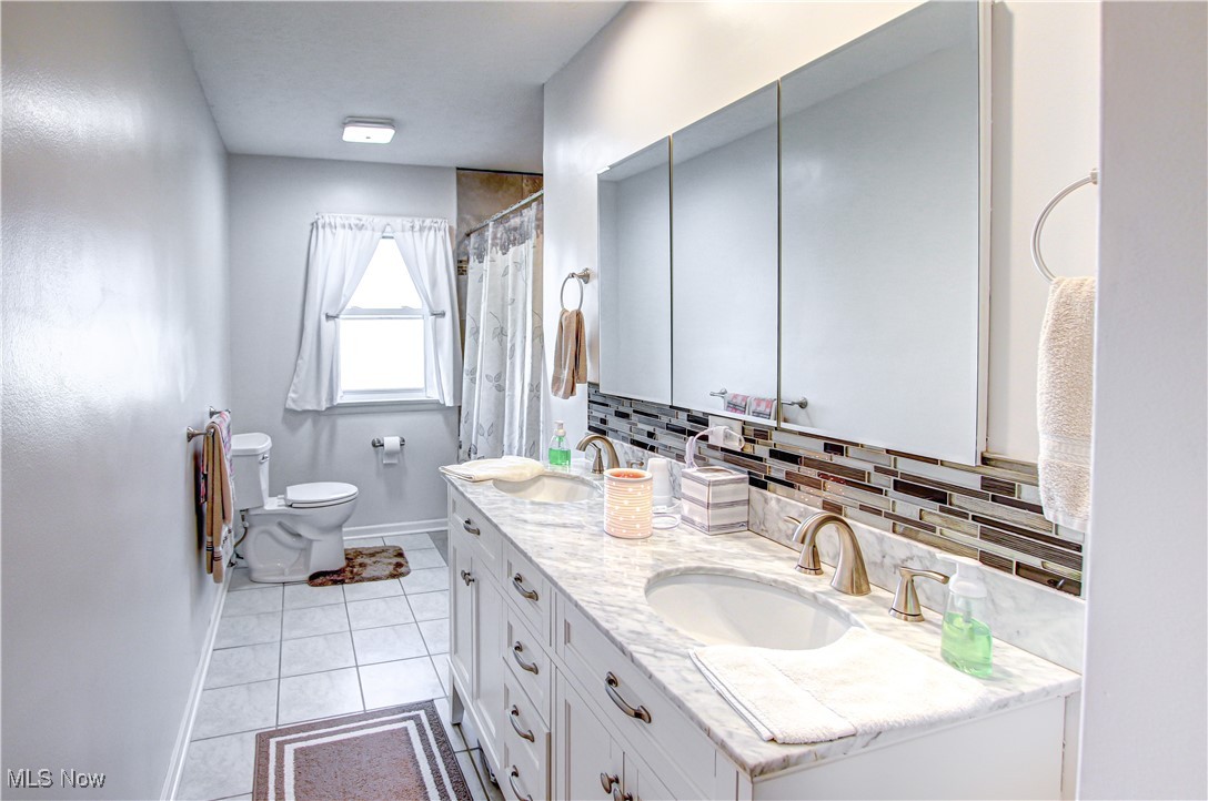 4234 Grafton Road Brunswick, OH 44212 - Photo 16 of 40 Bathroom with toilet, walk in shower, vanity, decorative backsplash, and tile patterned flooring