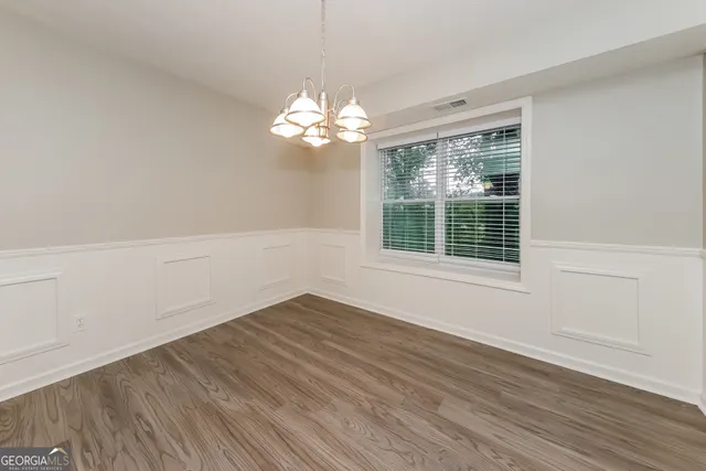 a view of a room with wooden floor and chandelier