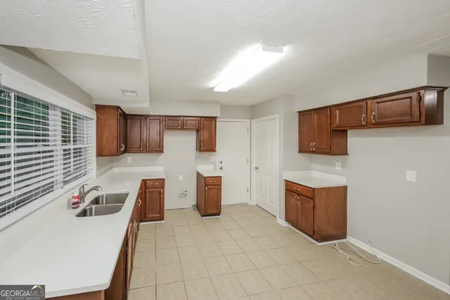 a view of kitchen with stainless steel appliances wooden cabinets stove top oven and microwave
