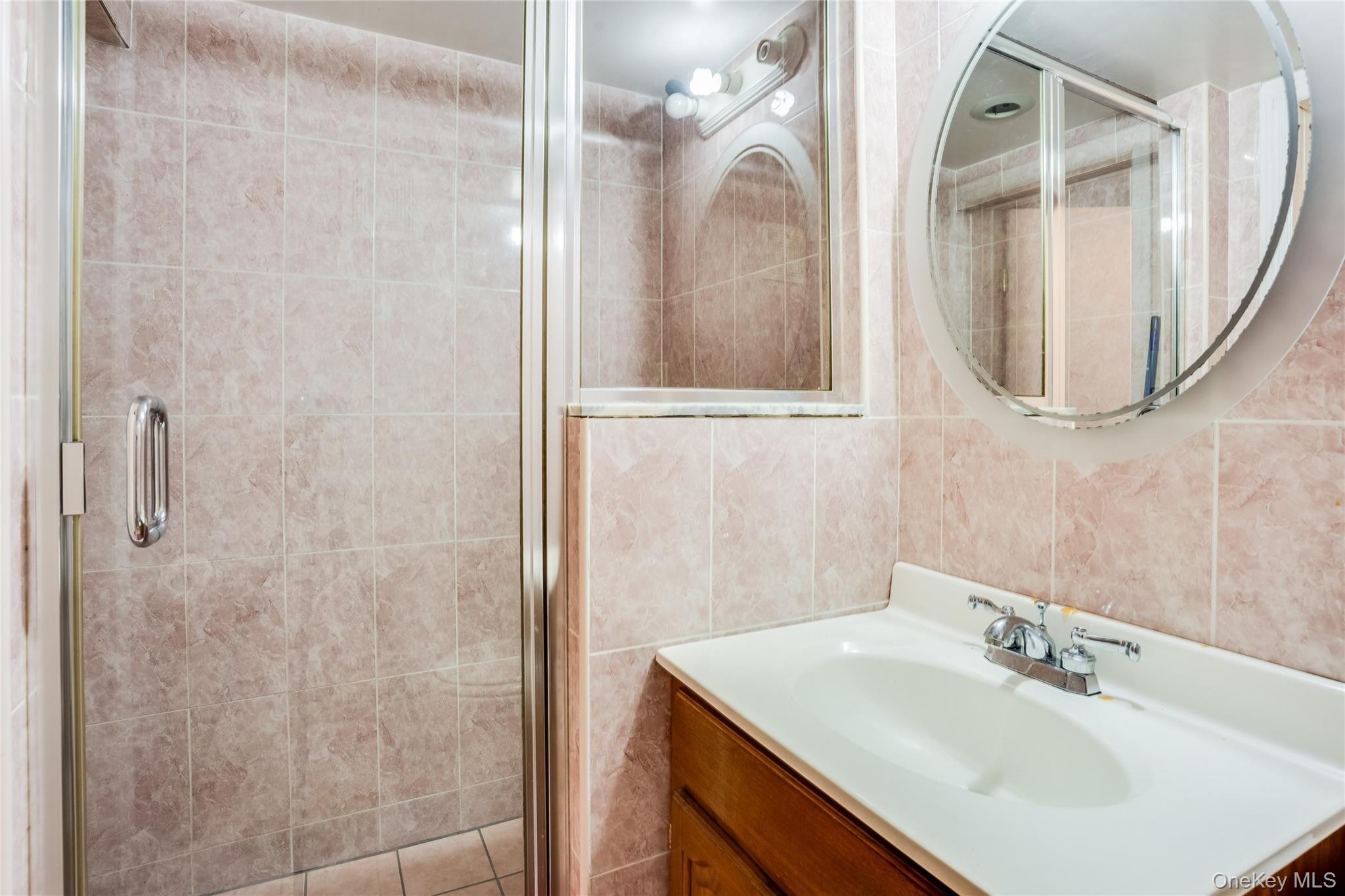 122 Hamilton Road Hempstead, NY 11550 - Photo 14 of 20 Full bathroom with vanity, a shower stall, and tile walls