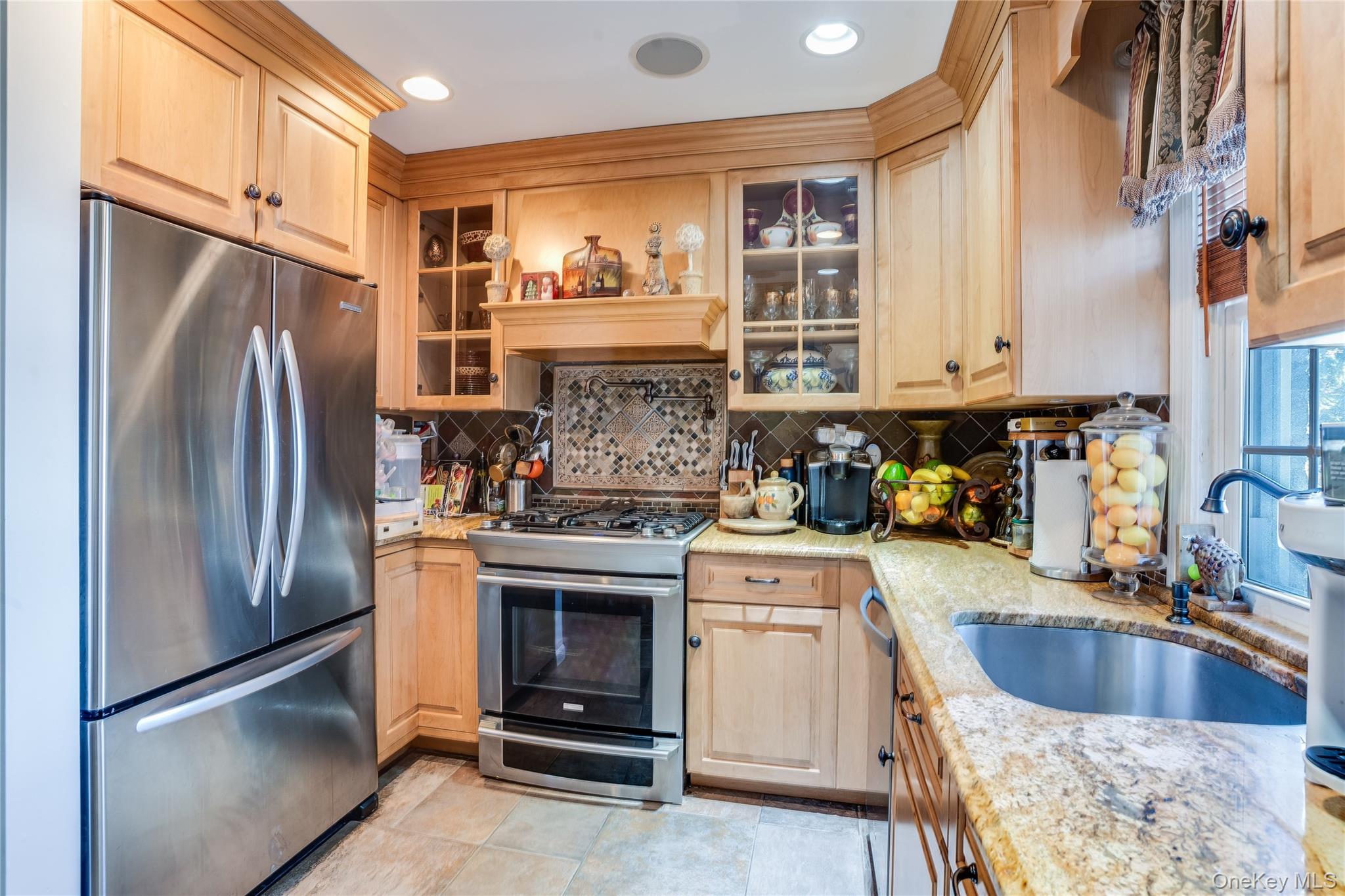 122 Hamilton Road Hempstead, NY 11550 - Photo 5 of 20 Kitchen with stainless steel appliances, light stone countertops, light brown cabinetry, glass insert cabinets, and backsplash