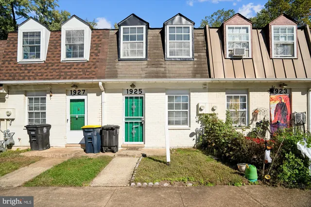 front view of house with a yard and potted plants