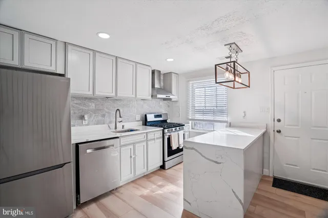 a kitchen with a sink stove cabinets and refrigerator