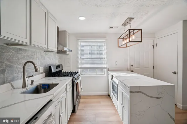 a kitchen with a sink stove and cabinets