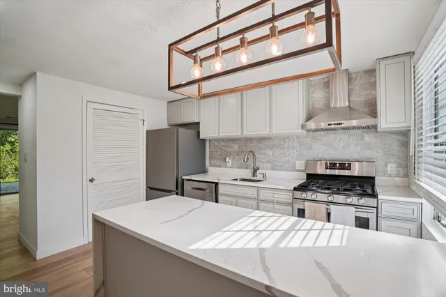 a kitchen with stainless steel appliances kitchen island granite countertop a stove and a refrigerator