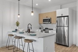 635 Main Street, Unit 209 Wilmington, MA 01887 - Photo 3 of 18 a kitchen with stainless steel appliances granite countertop a sink refrigerator and microwave