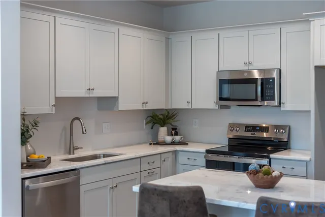 a living room with stainless steel appliances granite countertop furniture and wooden floor