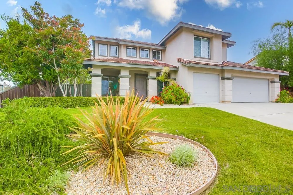a front view of a house with a garden and plants