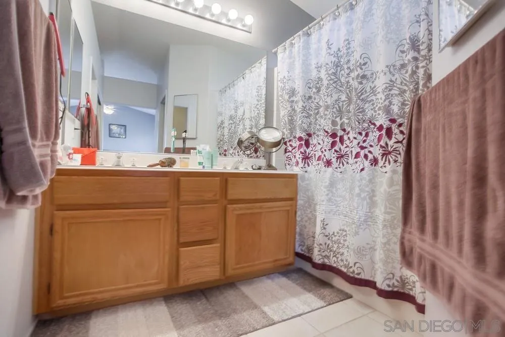 498 Shadow Tree Drive Oceanside, CA 92058 - Photo 28 of 42 a bathroom with a sink and a mirror