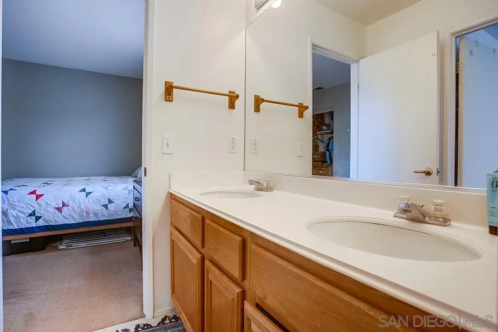 498 Shadow Tree Drive Oceanside, CA 92058 - Photo 30 of 42 a bathroom with a sink and a mirror