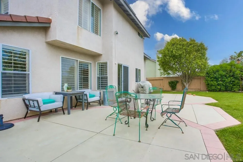 498 Shadow Tree Drive Oceanside, CA 92058 - Photo 37 of 42 a view of a patio with a dining table and chairs with a barbeque grill and a small yard