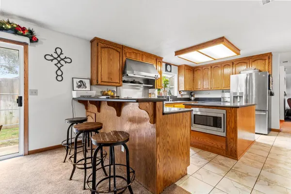 a large kitchen with stainless steel appliances granite countertop a stove a sink and a microwave
