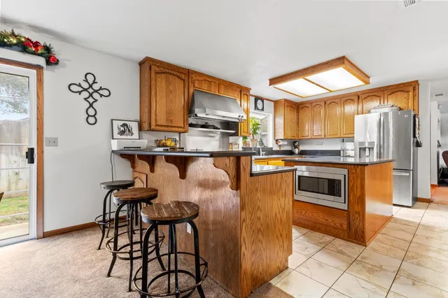 a kitchen with stainless steel appliances granite countertop a stove a sink and a refrigerator