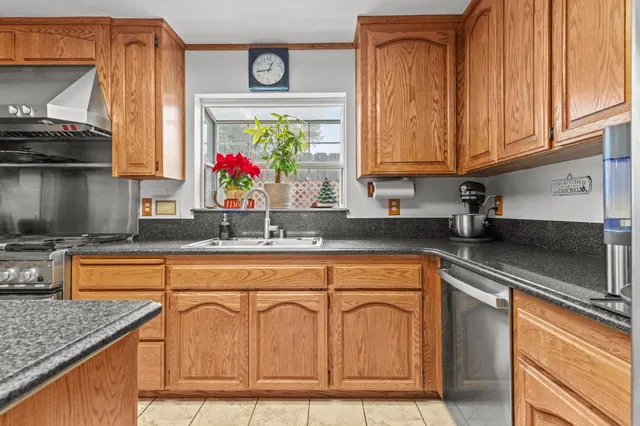 a kitchen with stainless steel appliances granite countertop a sink dishwasher stove and cabinets