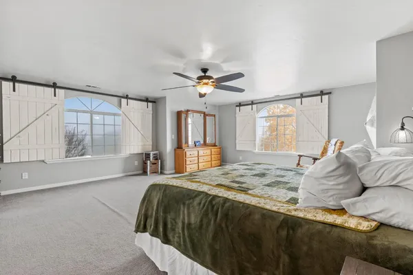 a bedroom with two beds and ceiling fan