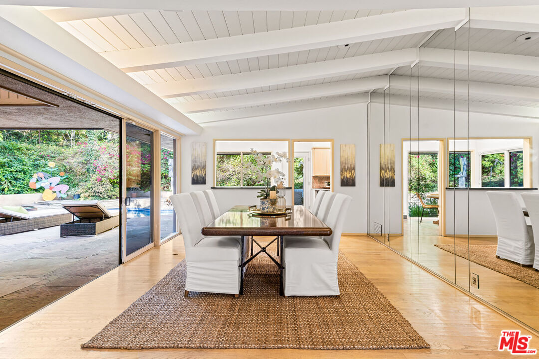 10871 Chalon Road Los Angeles, CA 90077 - Photo 15 of 41 a living room with a large window wooden floor table and chairs