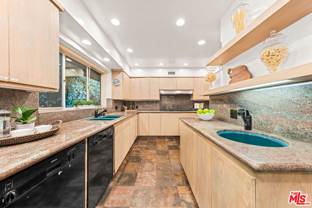 10871 Chalon Road Los Angeles, CA 90077 - Photo 18 of 41 a kitchen with kitchen island granite countertop a sink a counter top space stainless steel appliances and windows