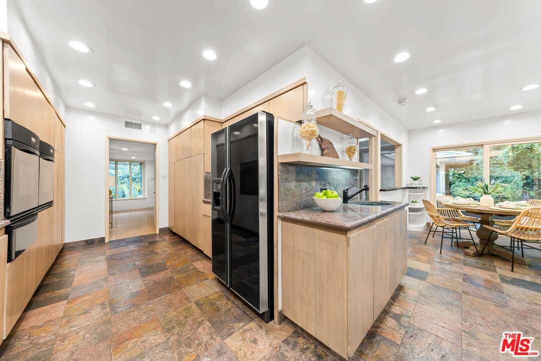 10871 Chalon Road Los Angeles, CA 90077 - Photo 19 of 41 a kitchen that has a lot of cabinets in it and stainless steel appliances